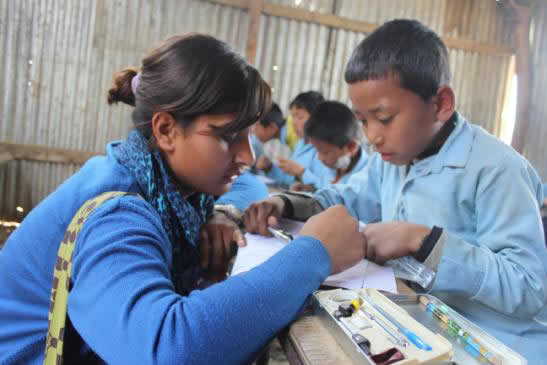 Nija, one of the TfN fellows, supporting a student in her class Nija, one of the TfN fellows, supporting a student in her class