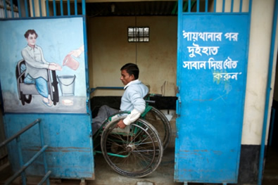 A disabled man uses the accessible latrine designed specifically to accommodate his needs, Beltola slum, Dhaka, Bangladesh A disabled man uses the accessible latrine designed specifically to accommodate his needs, Beltola slum, Dhaka, Bangladesh
